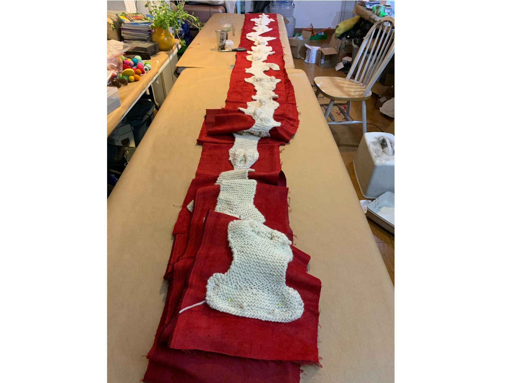 Knitted long meandering road backed with red cloth. Photo by Deborah Hunt. Carretera o meandro sujetada a tela roja. Foto de Deborah Hunt.