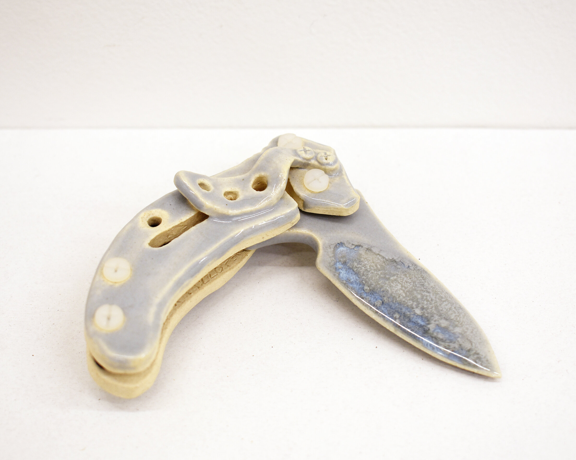  “Illusion of Self-Defense : Kershaw Replica (Assisted-Opening Pocket Knife” Closed- 1” x 2” x 4.5”, Open - 1” x 2” x 7”, Blade Length - 3”. Stoneware in 4 parts (white and brown clay bodies), vinyl screws and nuts, various glazes, 2021. 