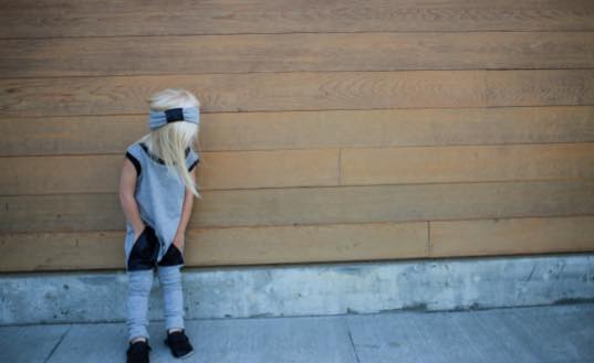 Harlan wearing the unisex romper and faux leather headband. 
