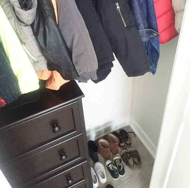 Coats and sweaters hanging, shoes on the floor where it's nice and easy for him to put them away neatly. 