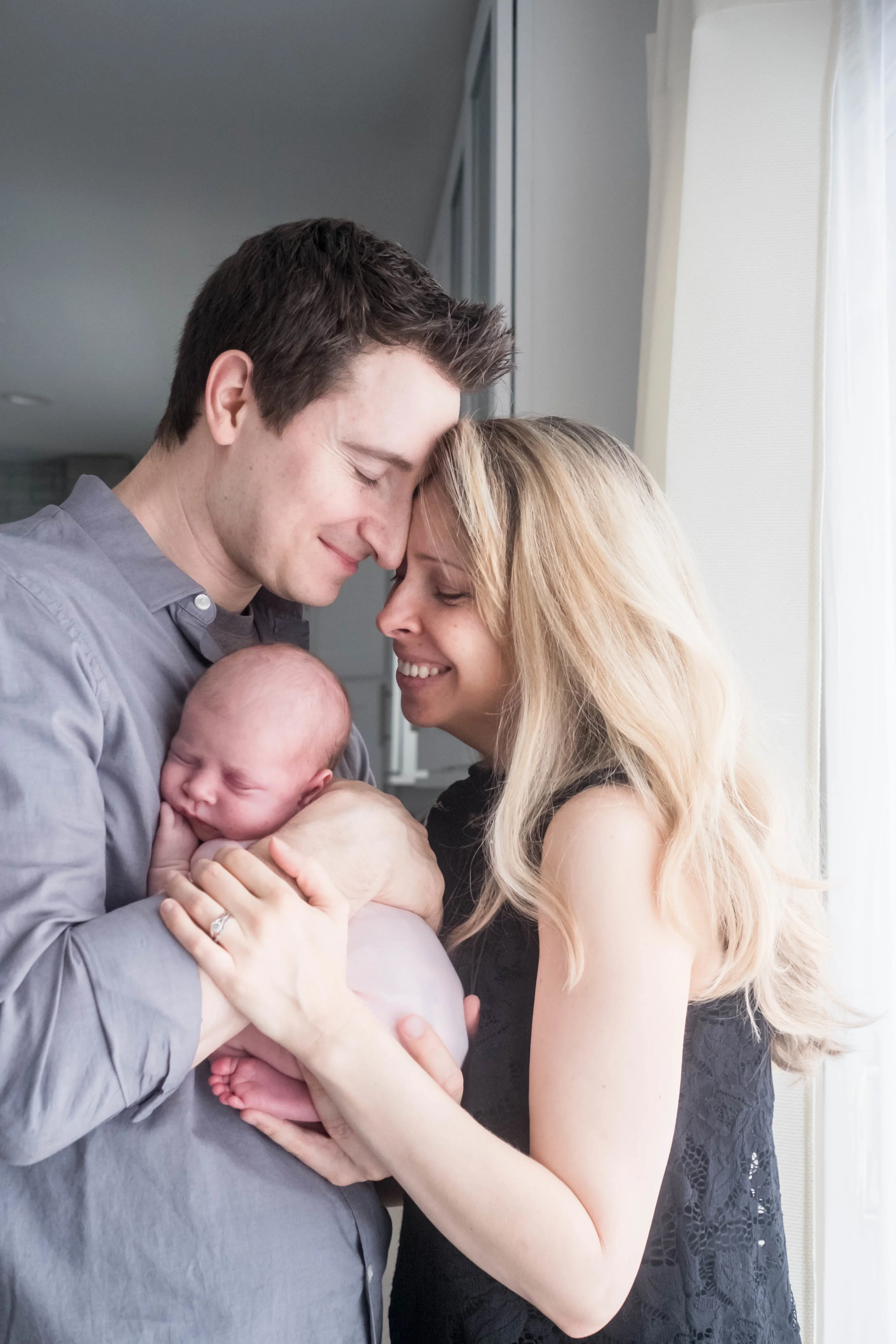new-parents-hold-newborn-by-window-chicago.jpg