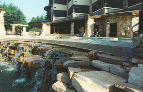 outdoor pool area with small rock waterfall at Sundara Inn & Spa in Lake Delton, WI