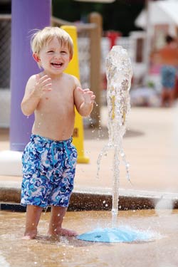 Kid playing by the water ground shooters at Bethpage Camp Resort in Urbanna, VA