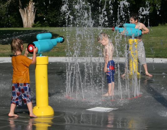Kids playing at the outdoor splash pad area at El Dorado Sprayground in KS