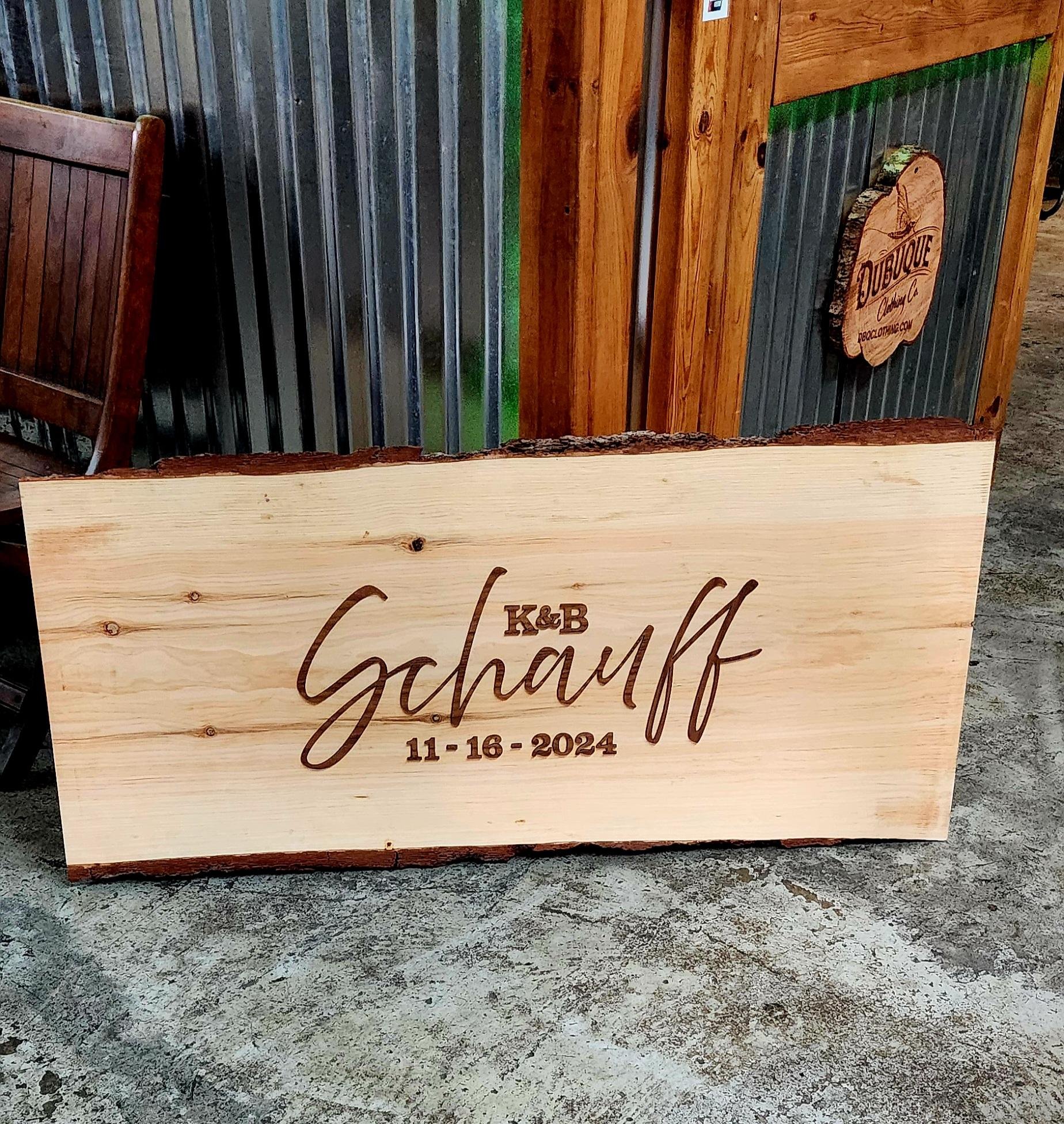 A 2'x4' wood slab custom-made for an upcoming wedding. Walnut letters are cut out and applied to give it depth. The plan is for guests to sign the board to create a unique piece to hang in their home. #smallbusiness #Dubuque #woodengraving #wedding #