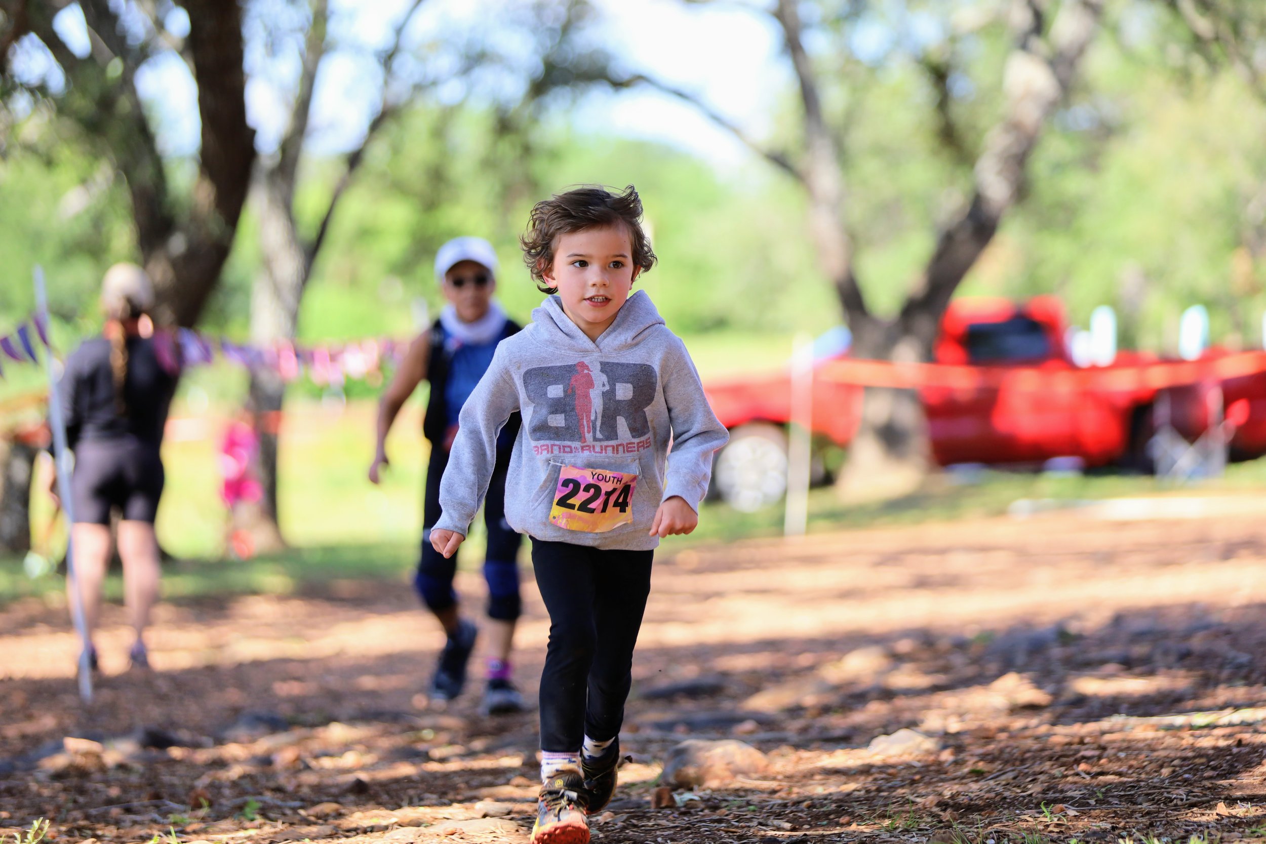  a young boy crossing the finish line of a trail race 