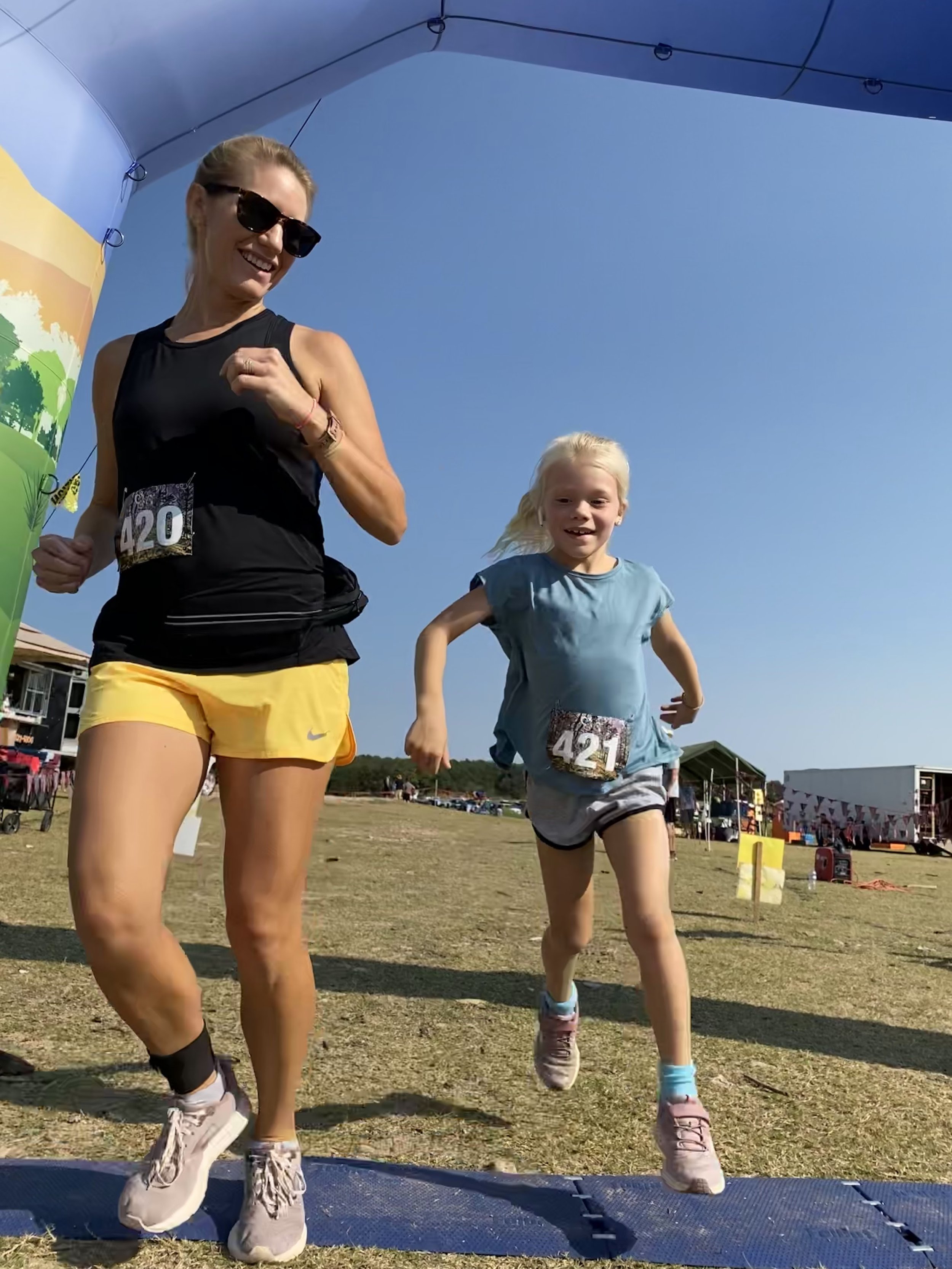  mother and daughter crossing the finish line of a trail race 