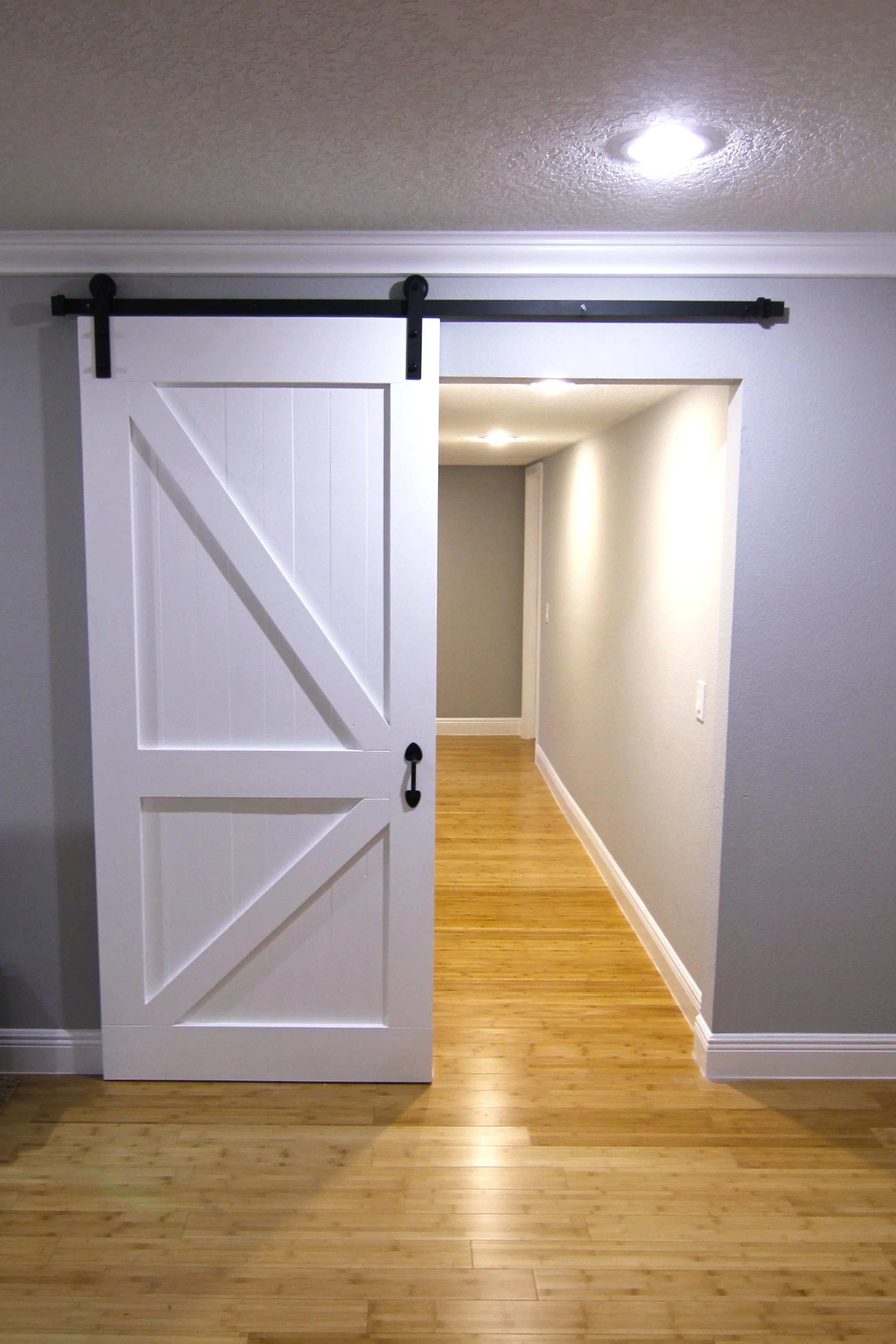 Sliding barn door painted white, solid wood construction