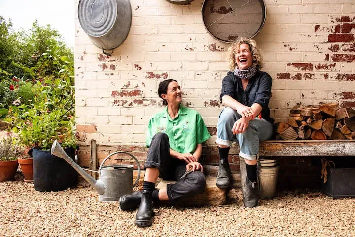 Avant Gardeners, Madeleine Gasparinatos and Emily Allen, sharing a laugh in the garden.