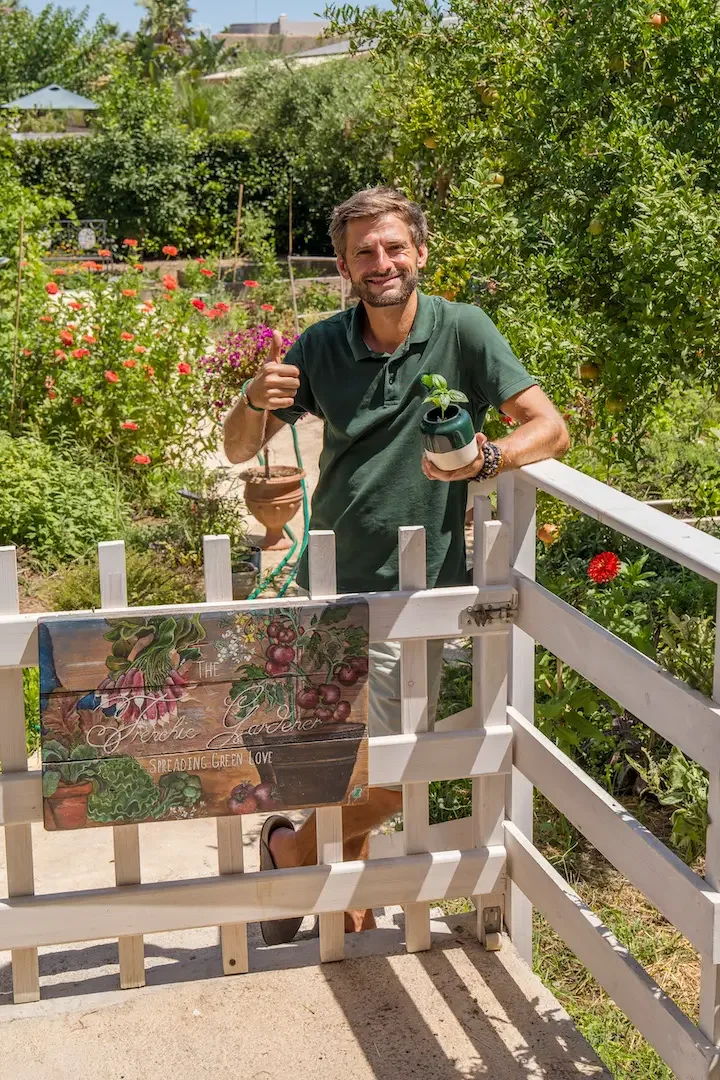 Patrick Vernuccio on balcony holding pots