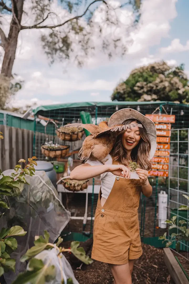 Connie Cao in the garden with a chicken on her shoulder
