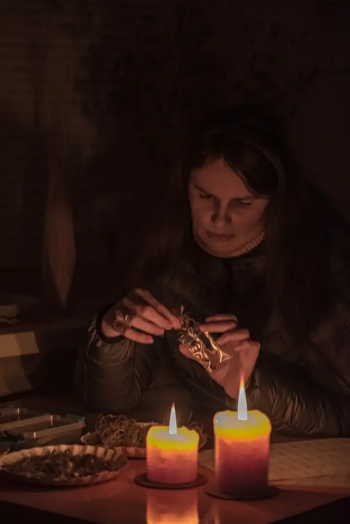 Alla Olkhovska packing seeds by candlelight during winter blackouts in Kharkiv