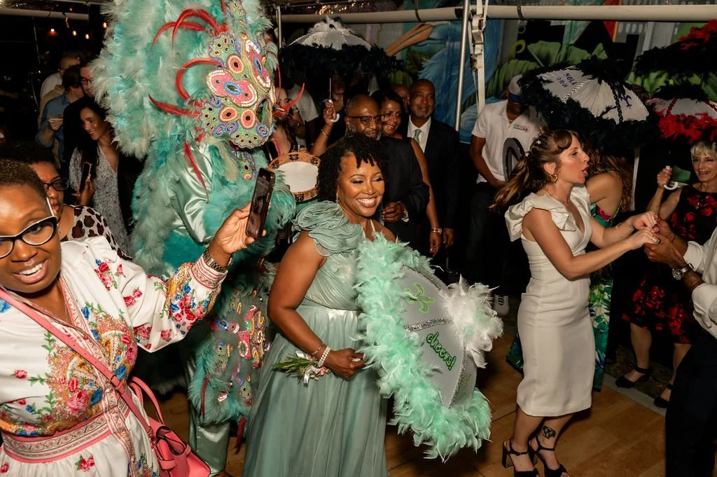 People wearing elaborate costumes and holding umbrellas, celebrating at a event.
