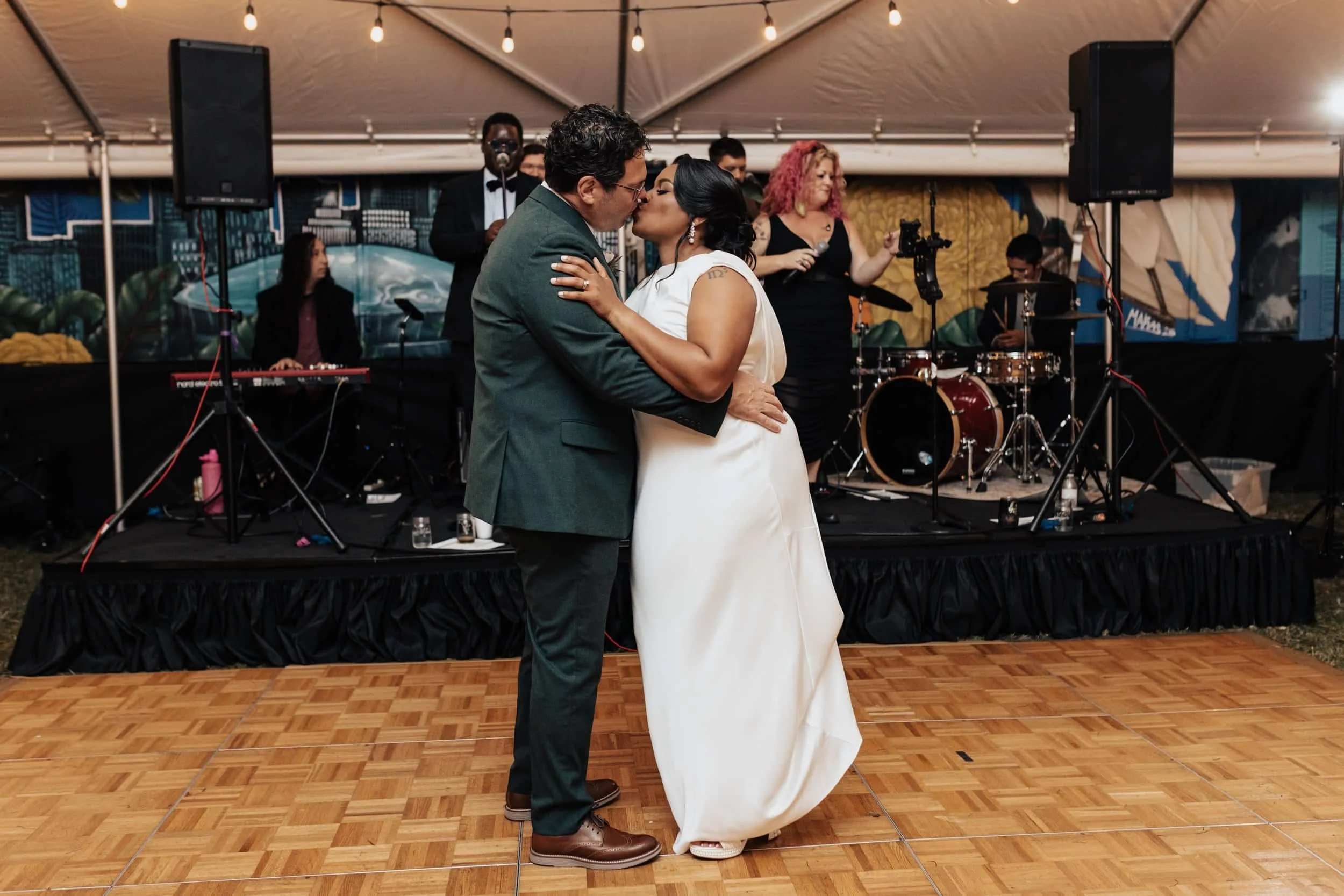 newly wed couple kissing during first dance under tent at New Orleans wedding venue