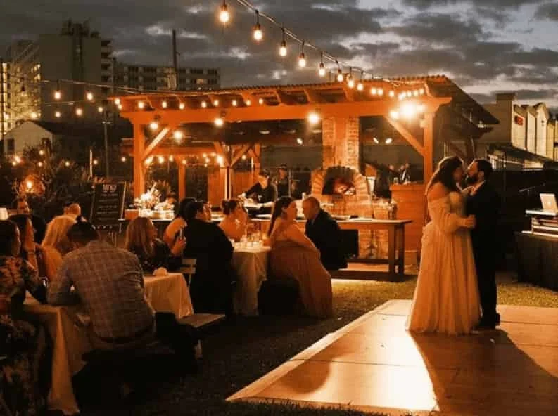 Bride and groom first dance while guests look on.