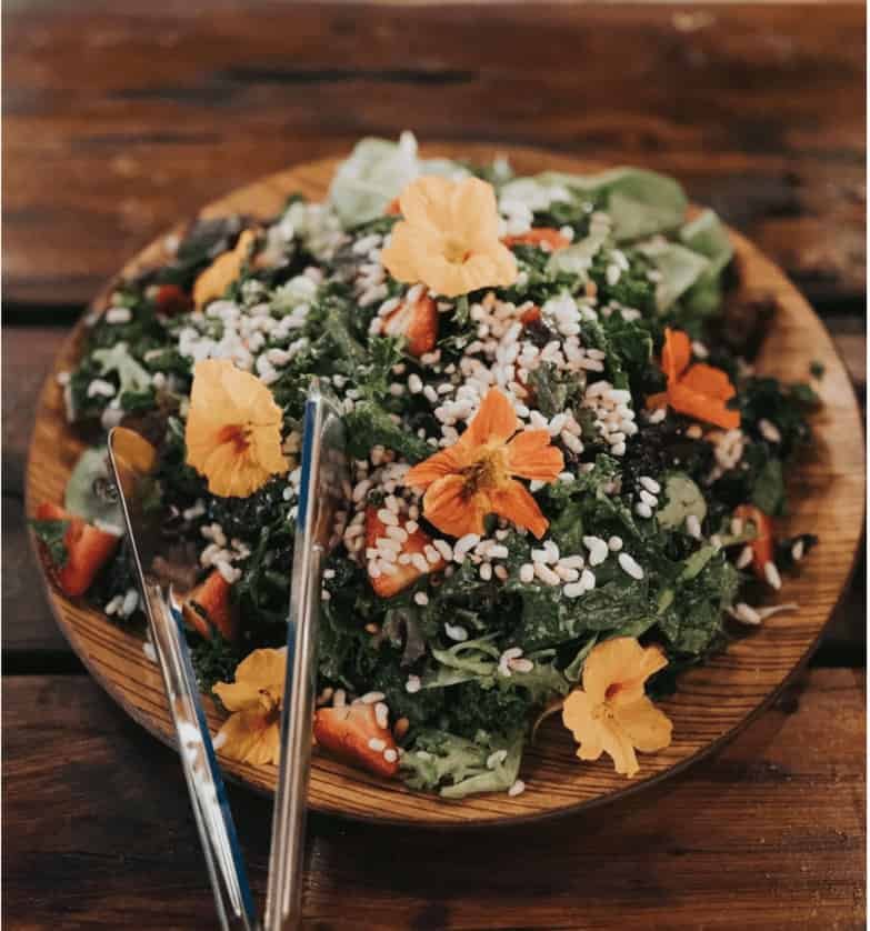 Freshly harvested farm-to-table salad with edible flower garnishes.