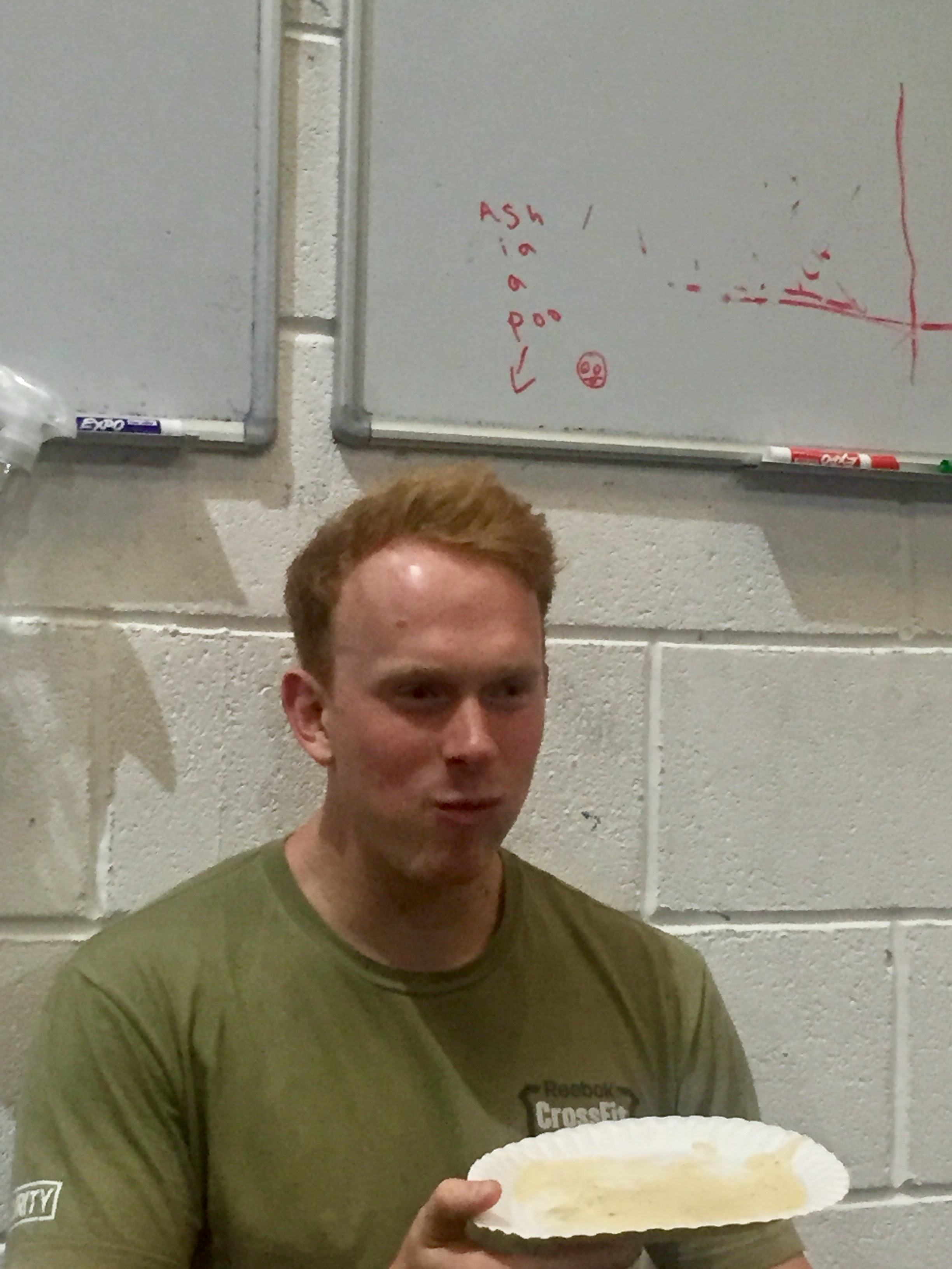 It looks like that whiteboard shout read..."Ash is HAVING a poo"