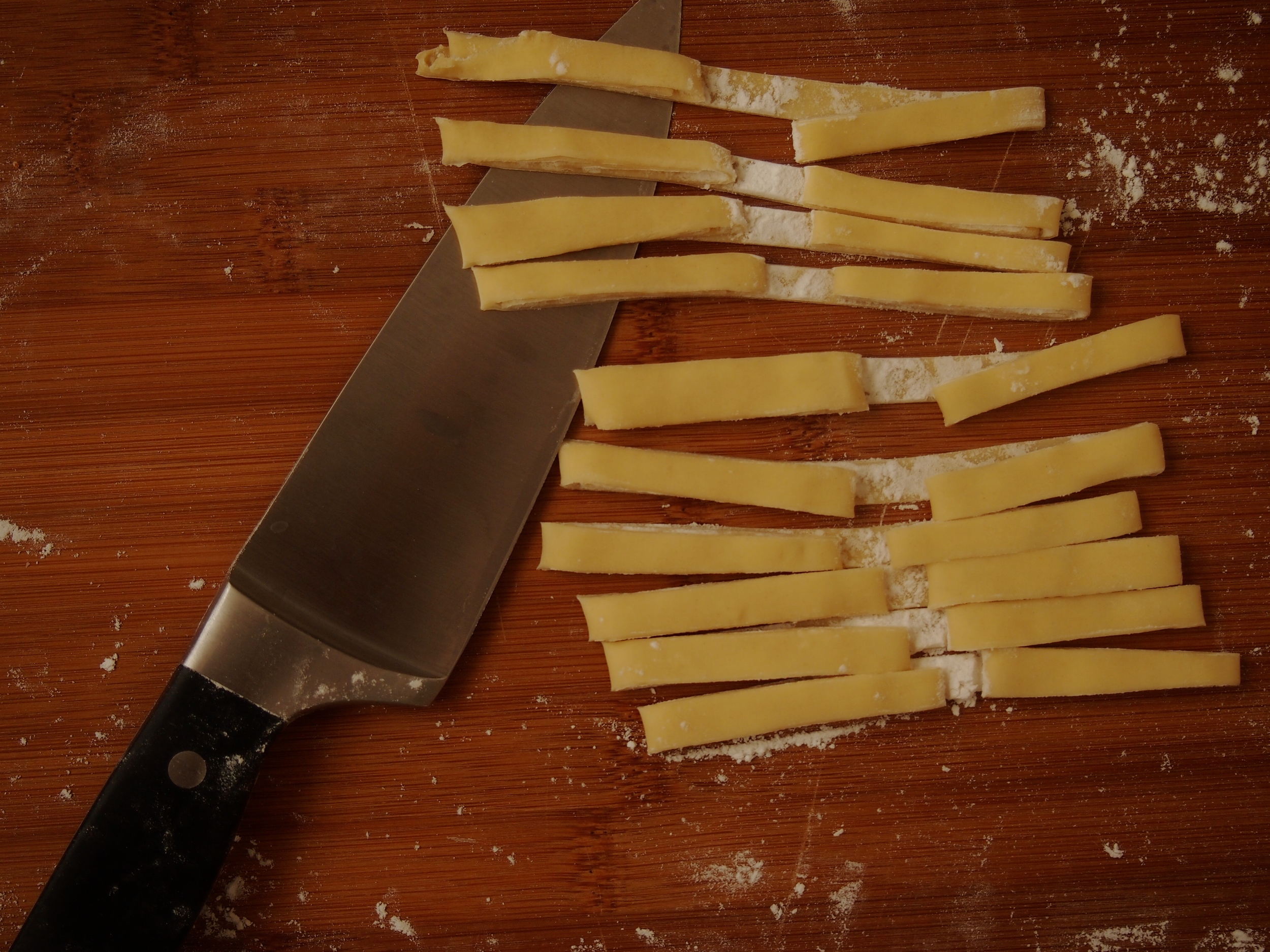 you don't even need a pasta roller, you can just roll it like a scroll, cut it and then hang it over your knife (see next pic)