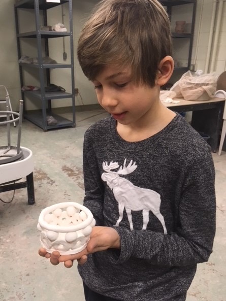 Boy holds clay vessel.jpg