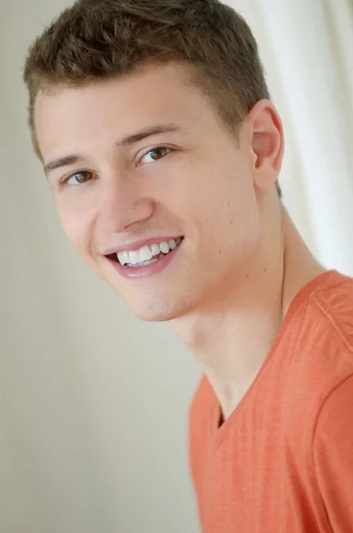 Happy looking teen boy in orange shirt 