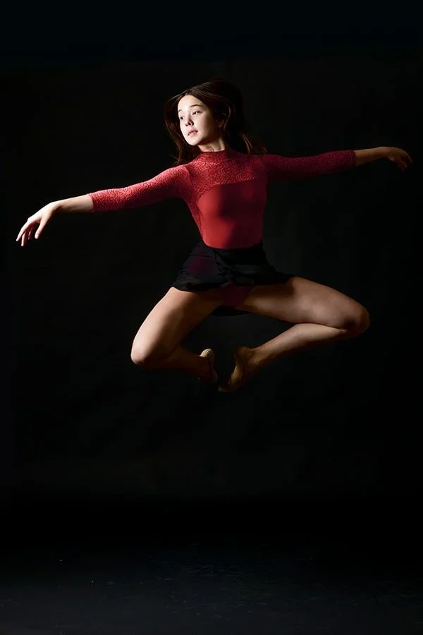dancer jumping  in red leotard
