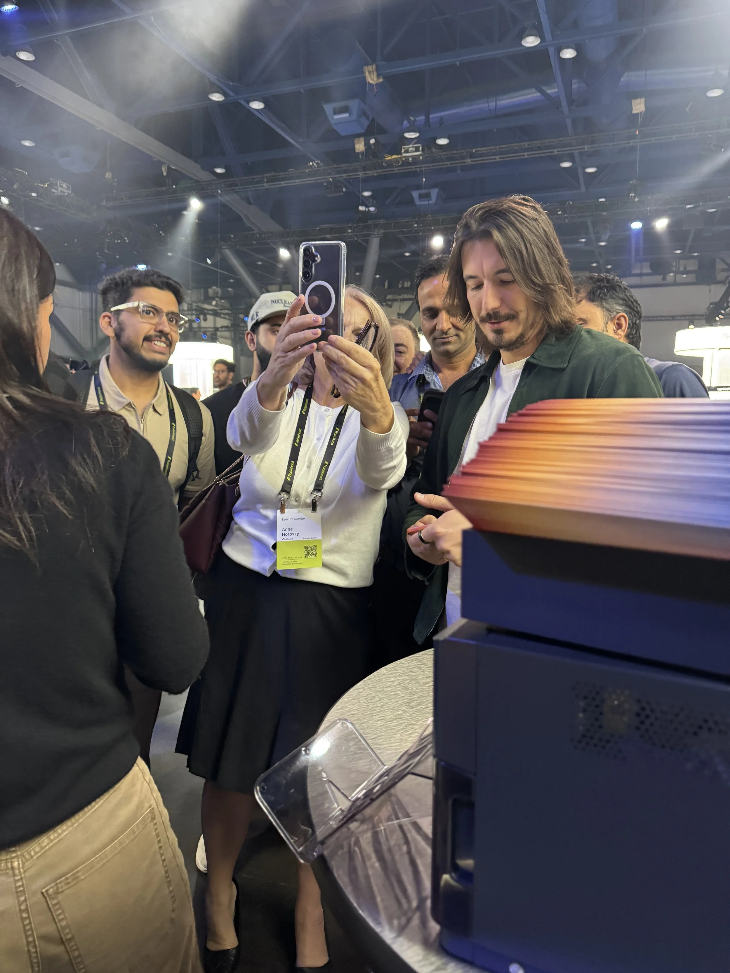 Robinhood CEO Vlad Tenev looking at his freshly printed aura portrait at the Fox and Darling booth for iShares by BlackRock, HOOD Summit '26