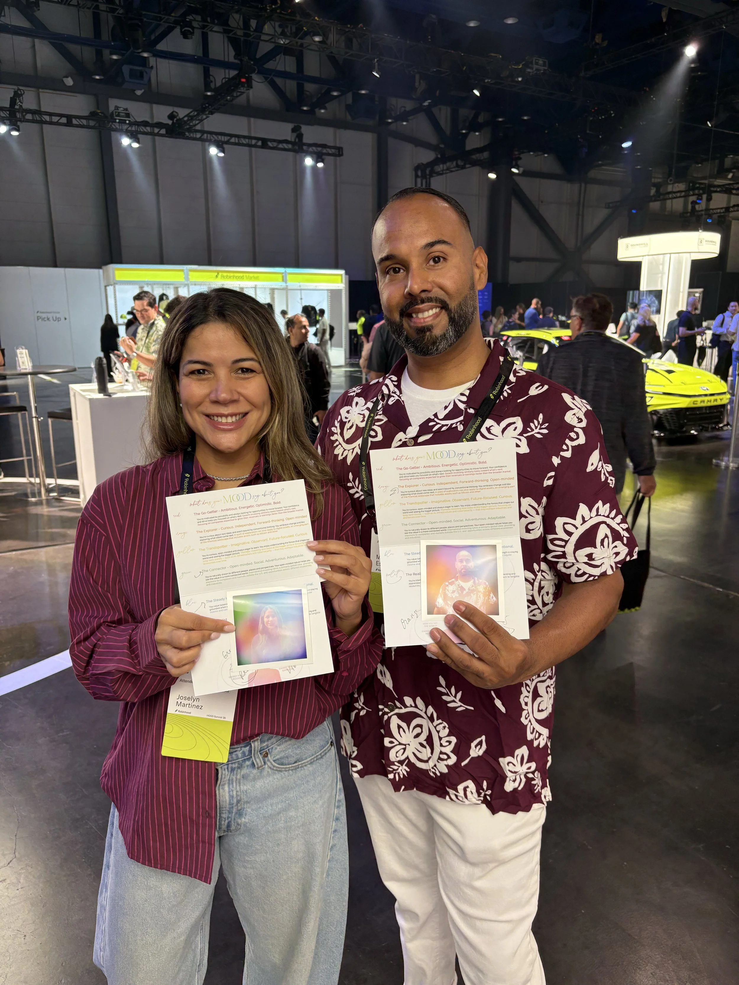 Two guests holding their aura prints at a trade show activation, Fox & Darling aura photo booth
