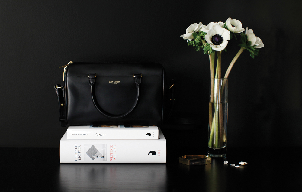 Photo by me, on my bedroom dresser - Saint Laurent baby duffle bag the same size as a good book, previous weekend read , Céline bracelet.