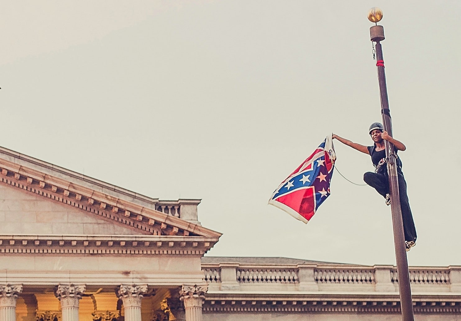Bree Newsome takes down the Confederate flag from a pole at the Statehouse Grounds in Columbia in 2015. Image credit: Washington Post