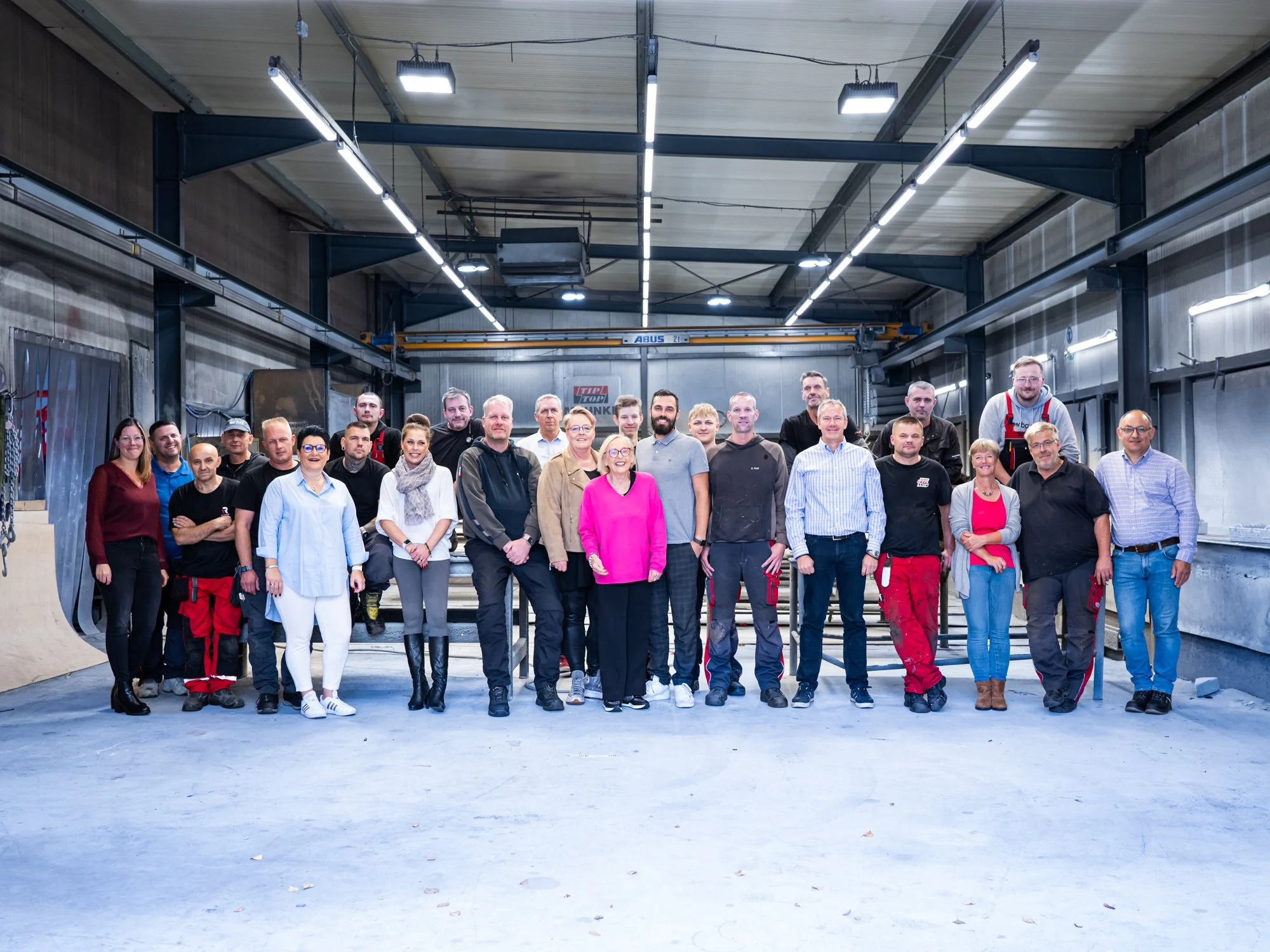 Gruppenbild von Menschen in einer Fabrikhalle.