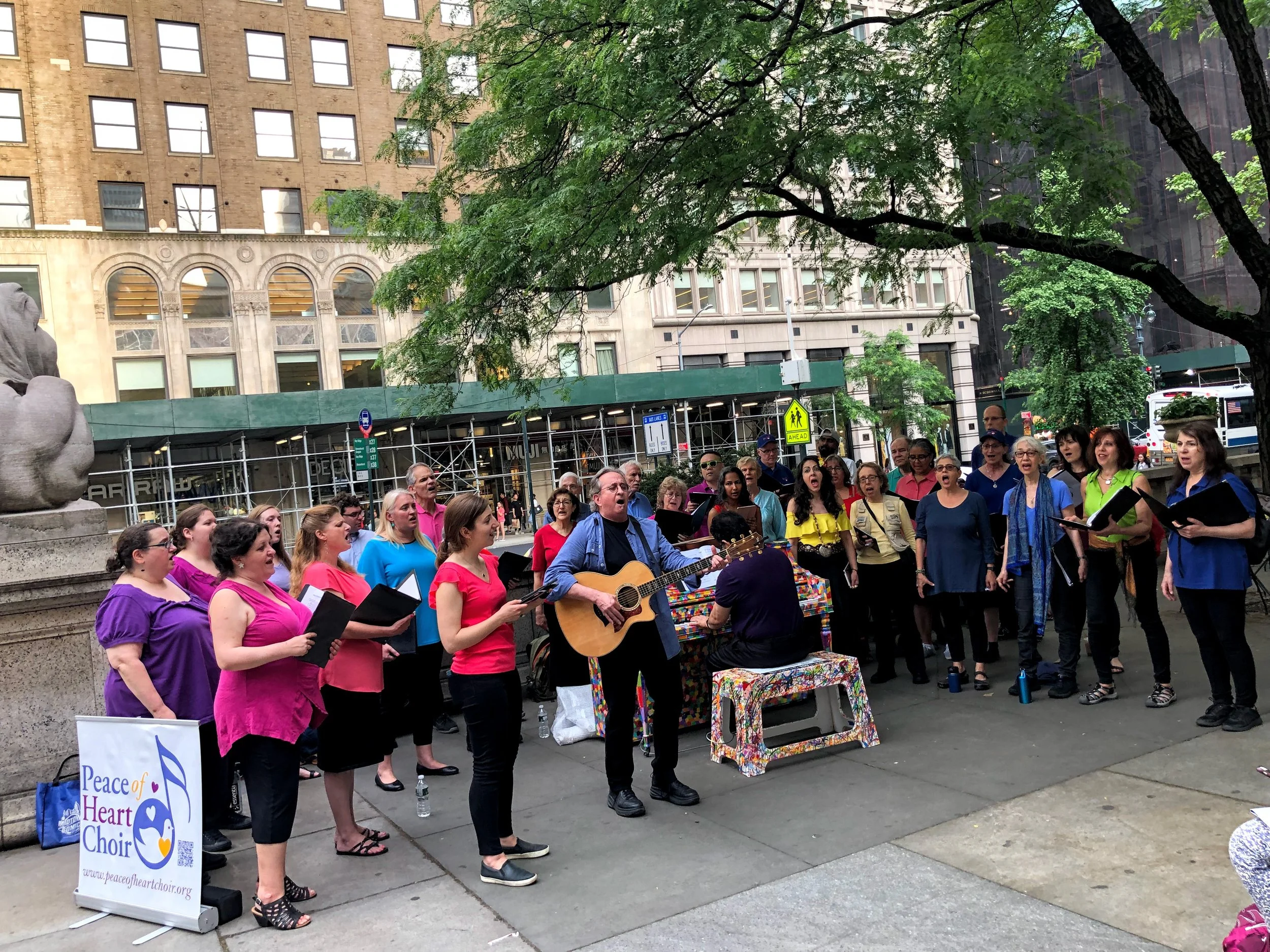 The choir sings near Patience, one of the famed lion statues, outside the NY Public Library on 5th Avenue.