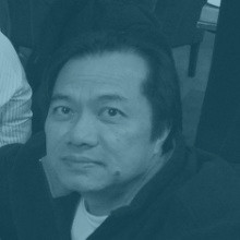 Corporate head shot of a man seated at a meeting.