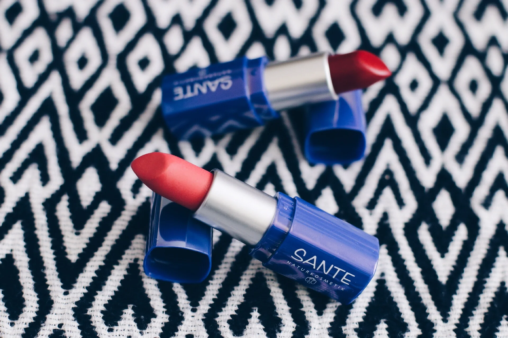 SANTE LIPSTICK IN "NO. 21 CORAL PINK" (FRONT) AND "NO. 23 POPPY RED" (BACK)