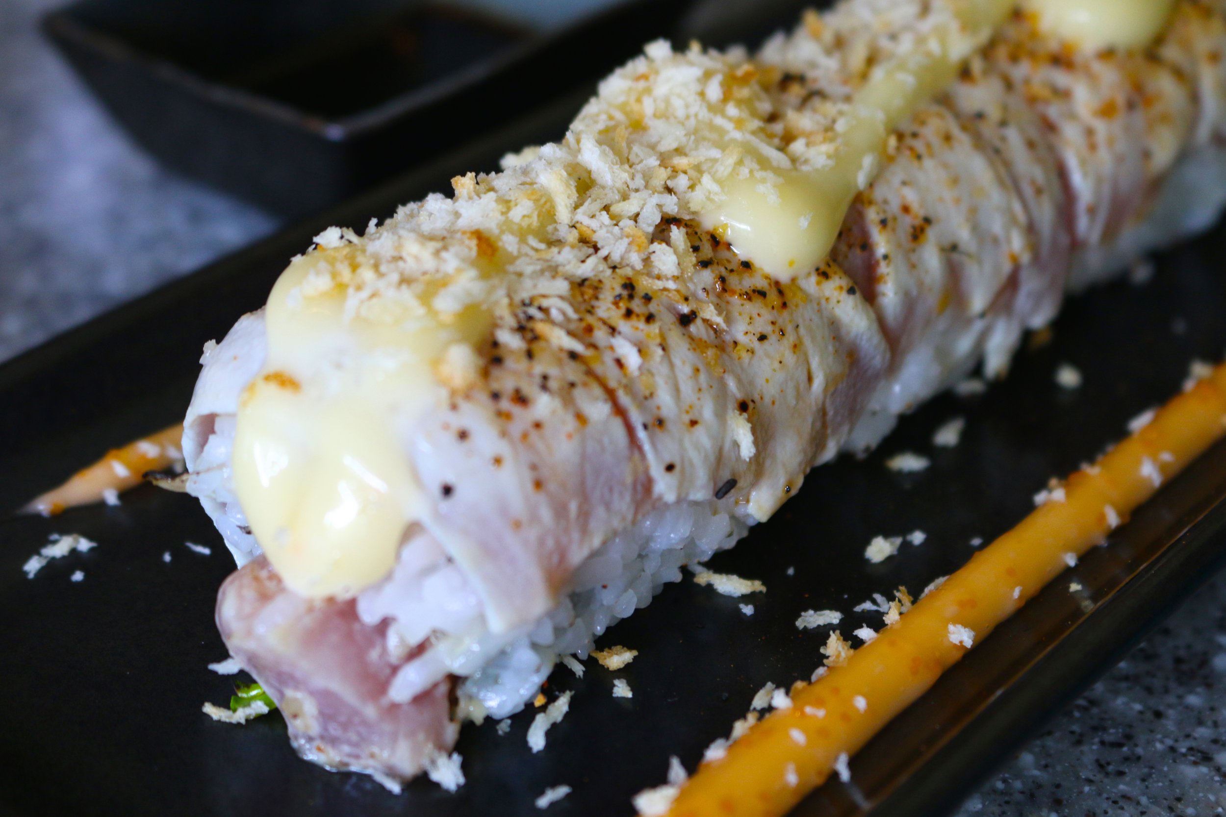 CAPT'N CRUNCH ROLL - spicy tuna tartare, macadamia nuts, daikon, seared ahi, and panko crisps