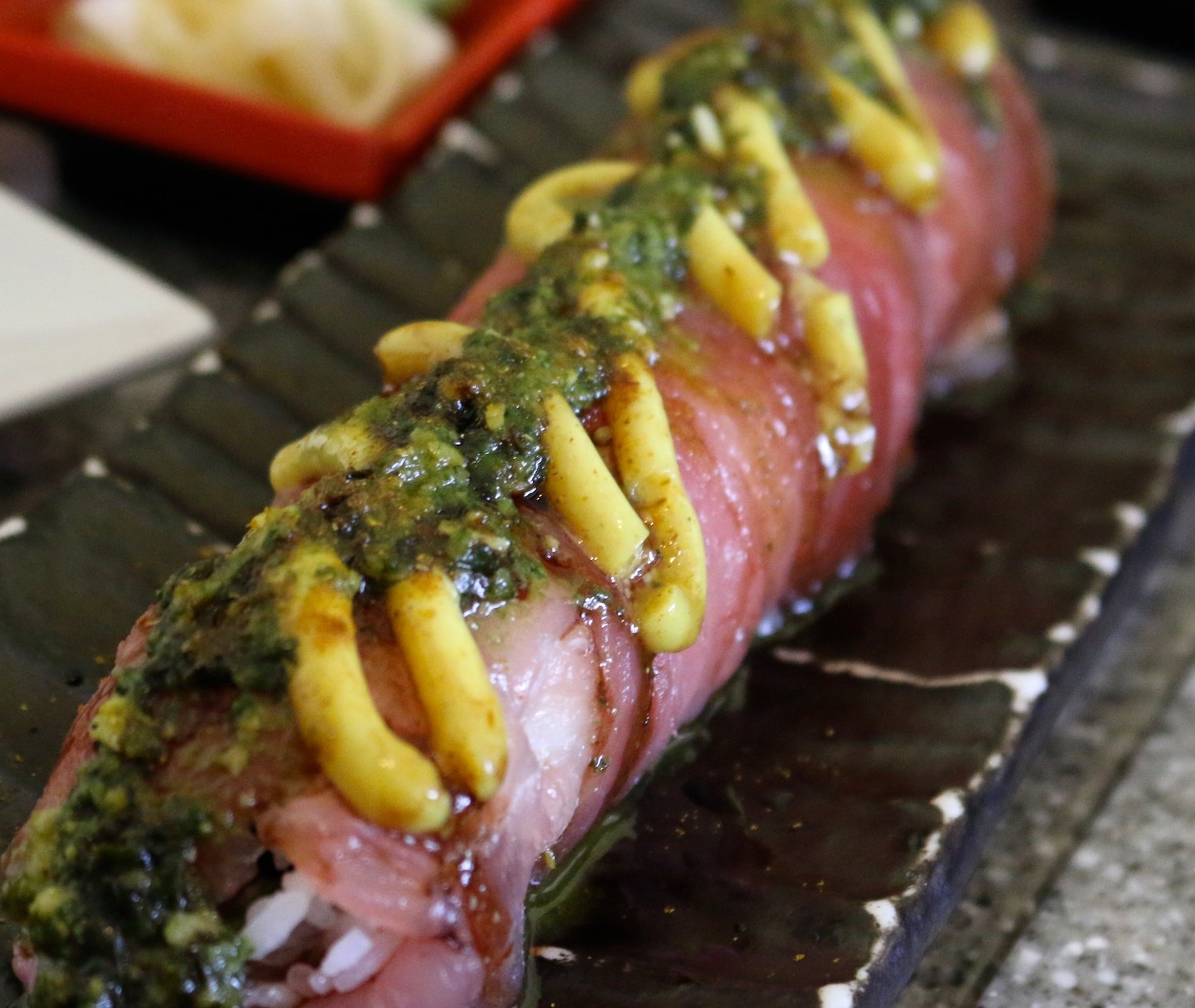 BOMBAY SUNSET ROLL - ahi poke, curry slaw, and Fuji apple wrapped with sashimi of the day