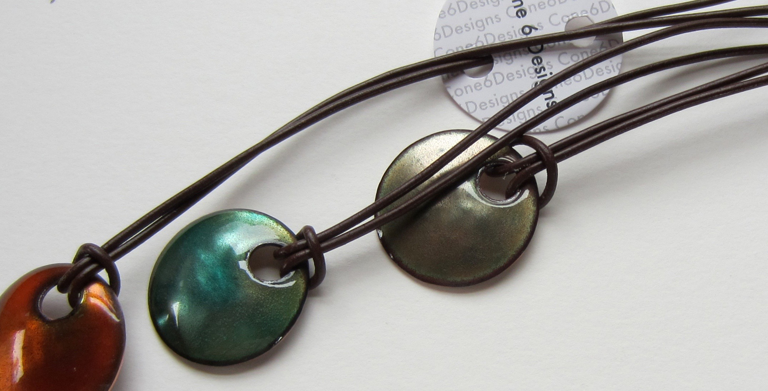 Three domed 1 1/4 inch necklaces. Enamel on Copper with leather necklace.