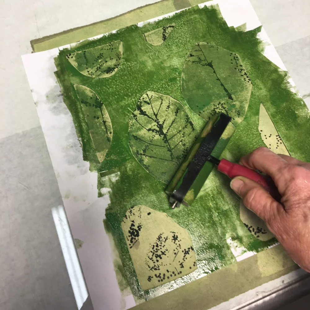 Rolling on another layer of green through a paper mask.