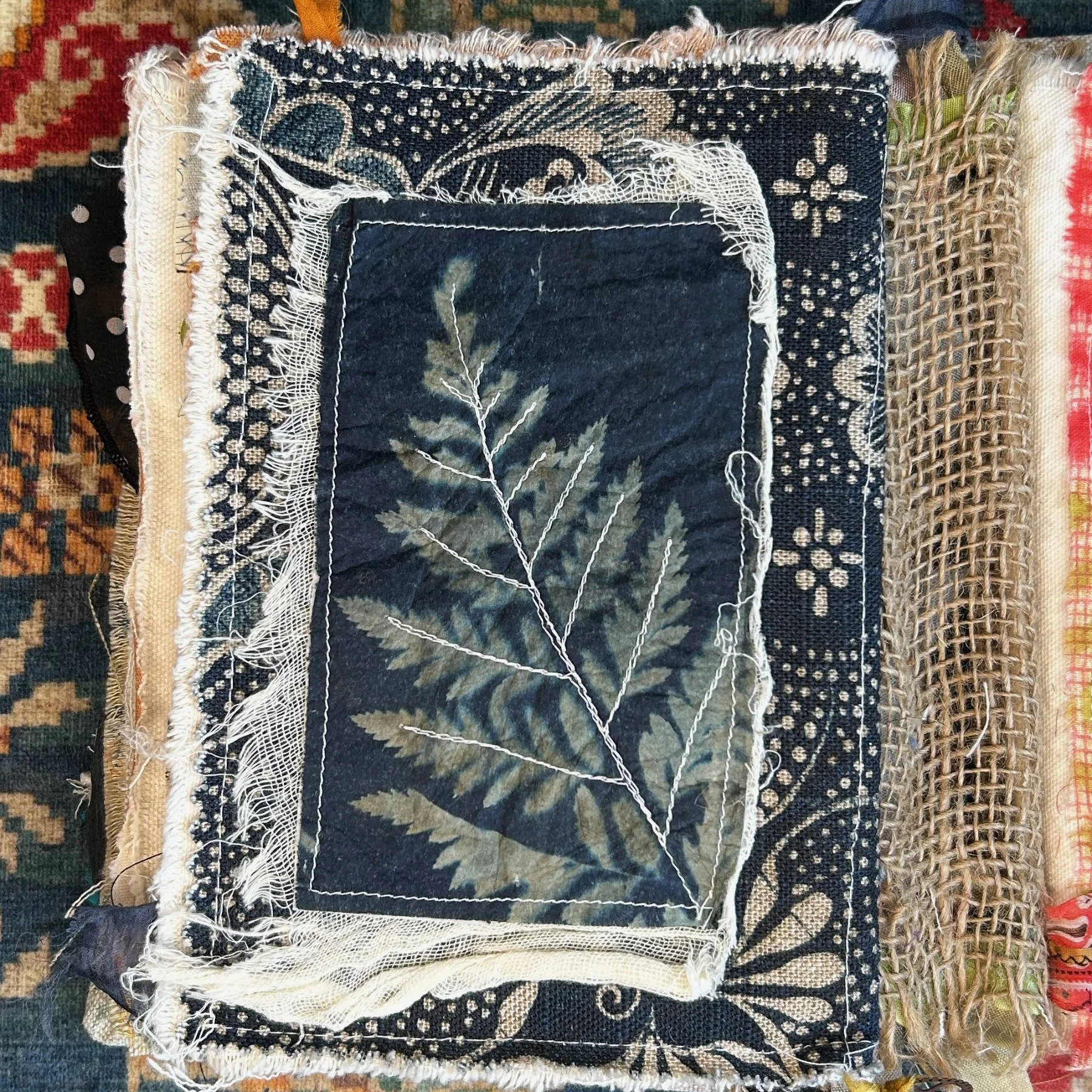 Fern on cyanotype tea bag as a page in a journal with stitching