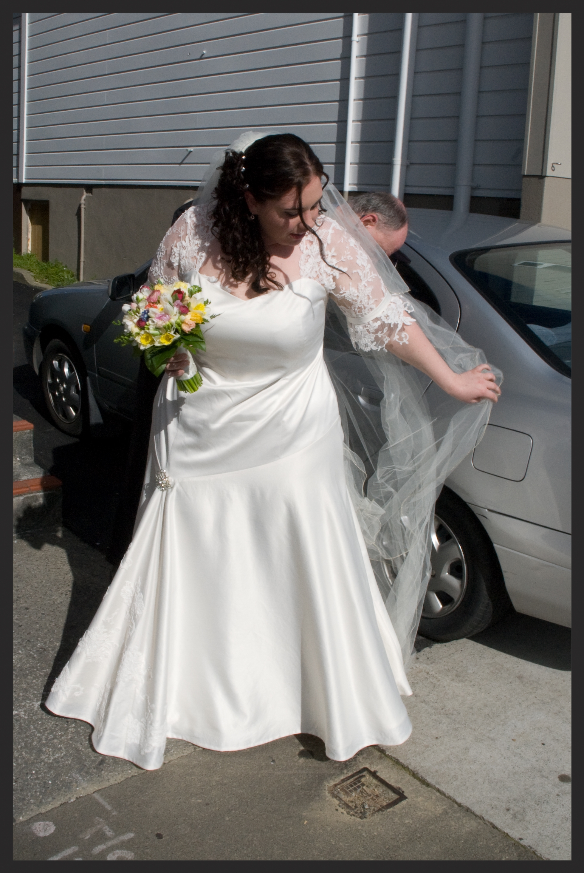 Lauryn wanted a romantic style for her gown. She had purchased a stunning piece of french chantilly lace and a vintage brooch from overseas that she was keen to incorporate into the design. As we only had 1m of the lace to work with we used it to its maximum. The top of the dress and sleeves were left unlined to allow the delicate lace to show clearly. Then individual flowers were cut from the lace and hand sewn onto the front of the skirt, flowing down from the brooch she supplied.
