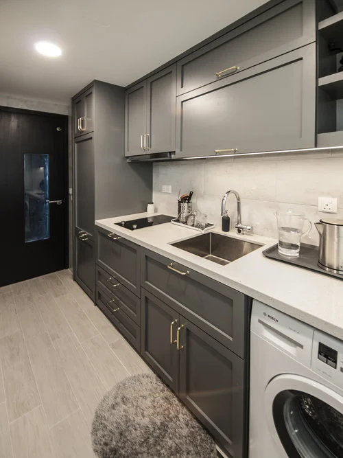 This small transitional kitchen packs a concealed refrigerator, washing machine and microwave!