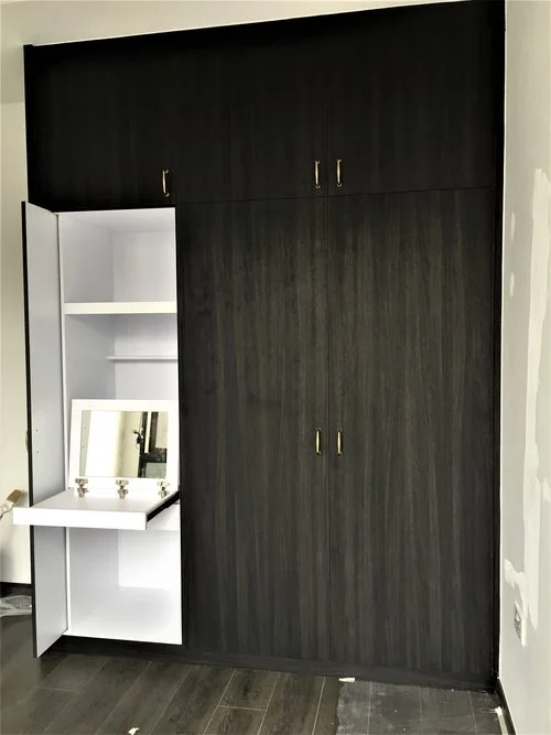 Built-in dresser with retractable wardrobe door featuring a pull-out table top fitted with a mirror.