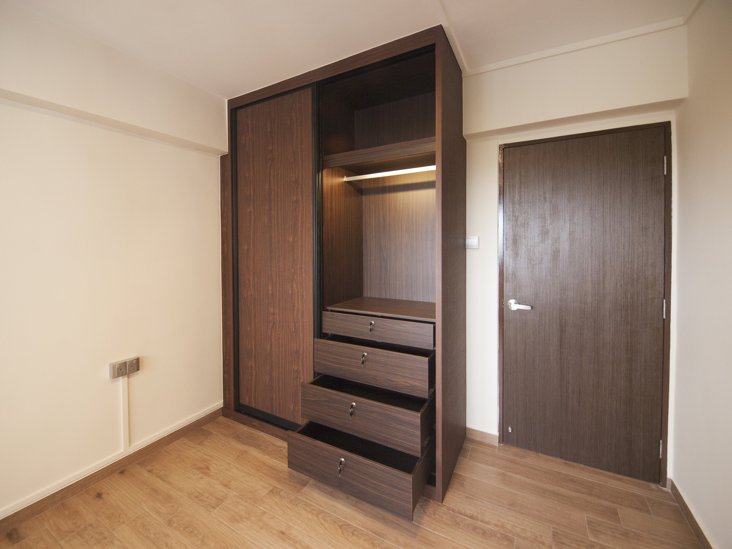 A sliding wardrobe with a concealed pull-out mirror under the ceiling beam.