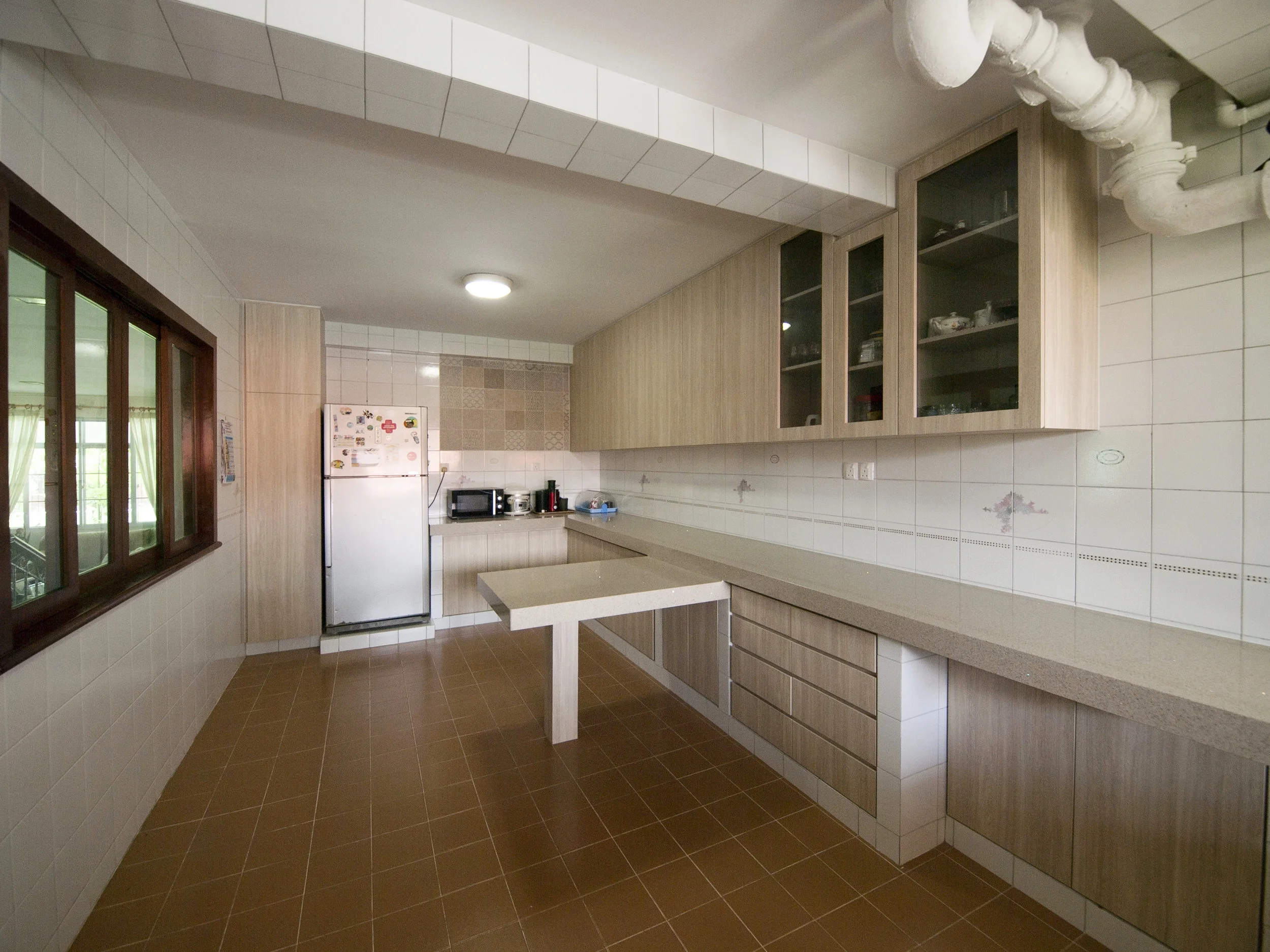 It was a challenge to revamp the kitchen but preserve the original concrete structure for the cabinets and floor and wall tiles. We achieved a brighter, more airy feel for a pleasant cooking experience.