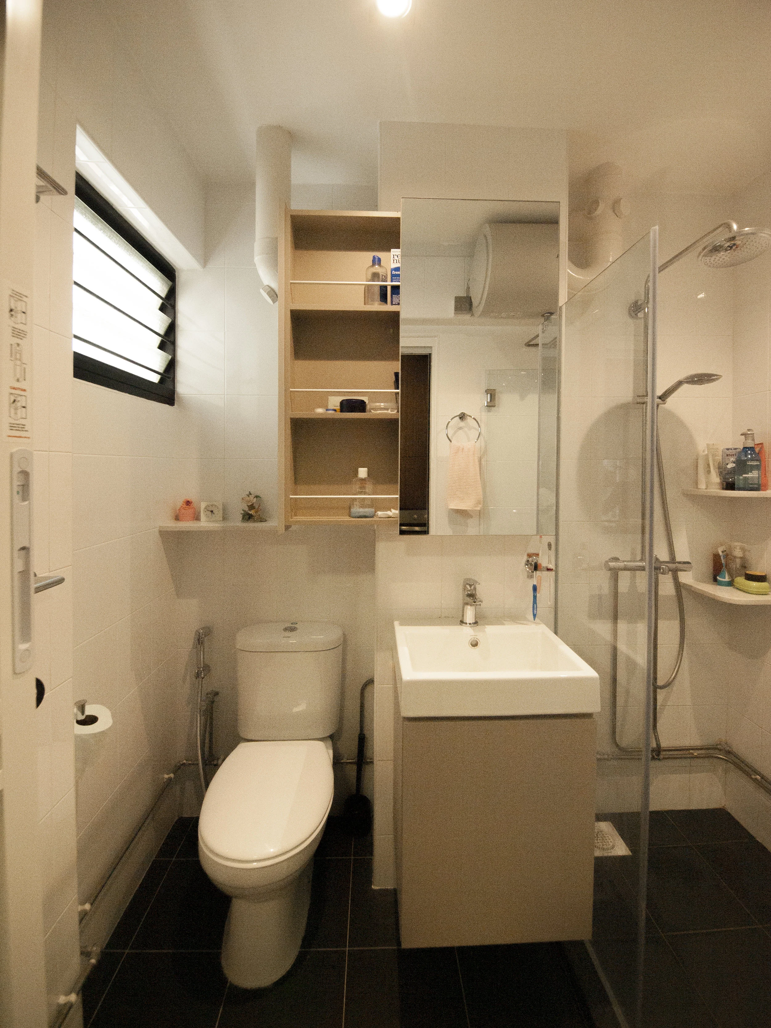 Concealed the floor to ceiling pipes partially to maximise the space and give a clean look. A sliding mirror cabinet allows you to use the mirror while accessing your bathroom essentials!
