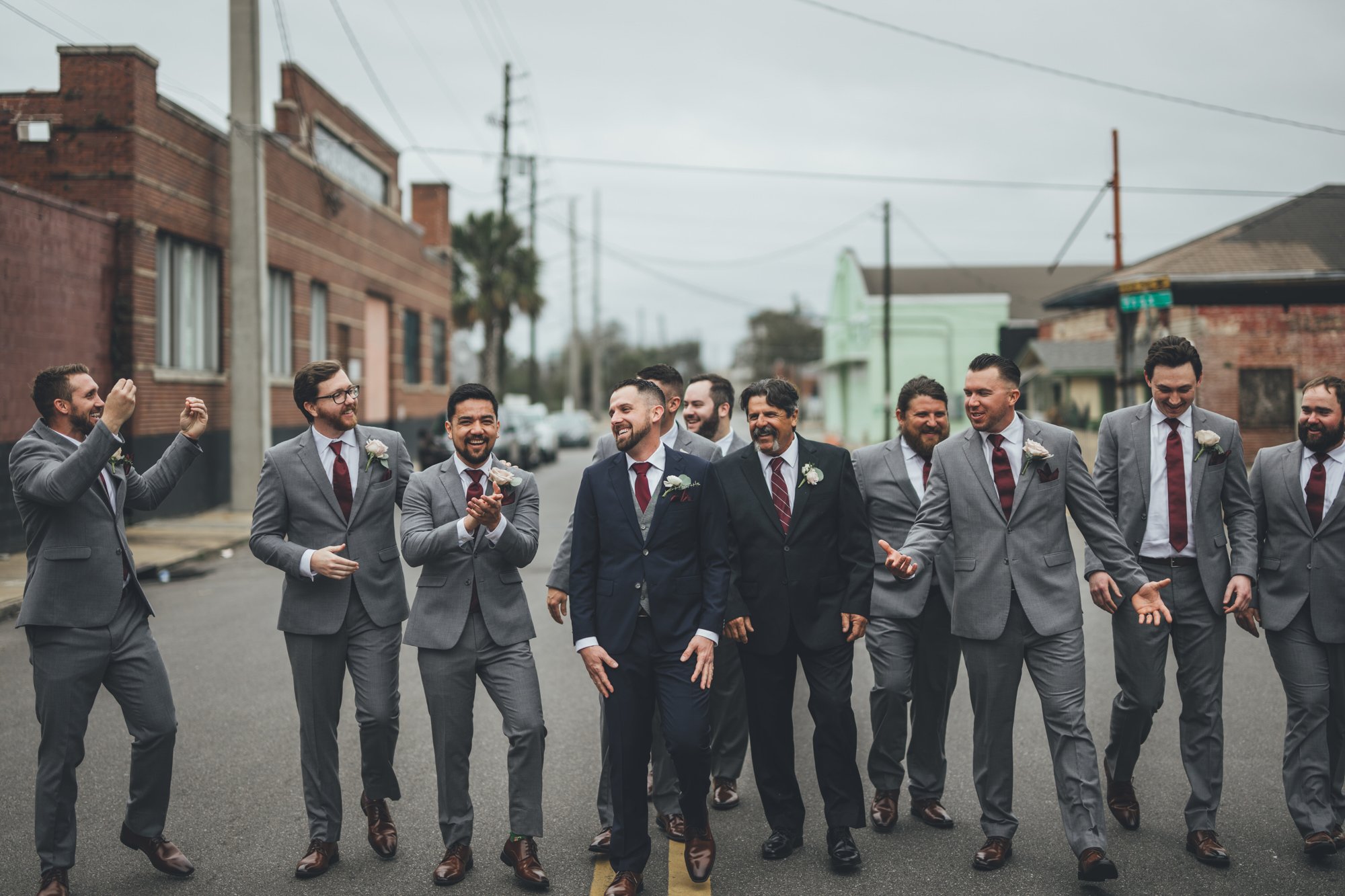 Bow Tie Photo & Video groom walks with groomsment down street outside of The Glass Factory before wedding in Jacksonville, Florida.jpg