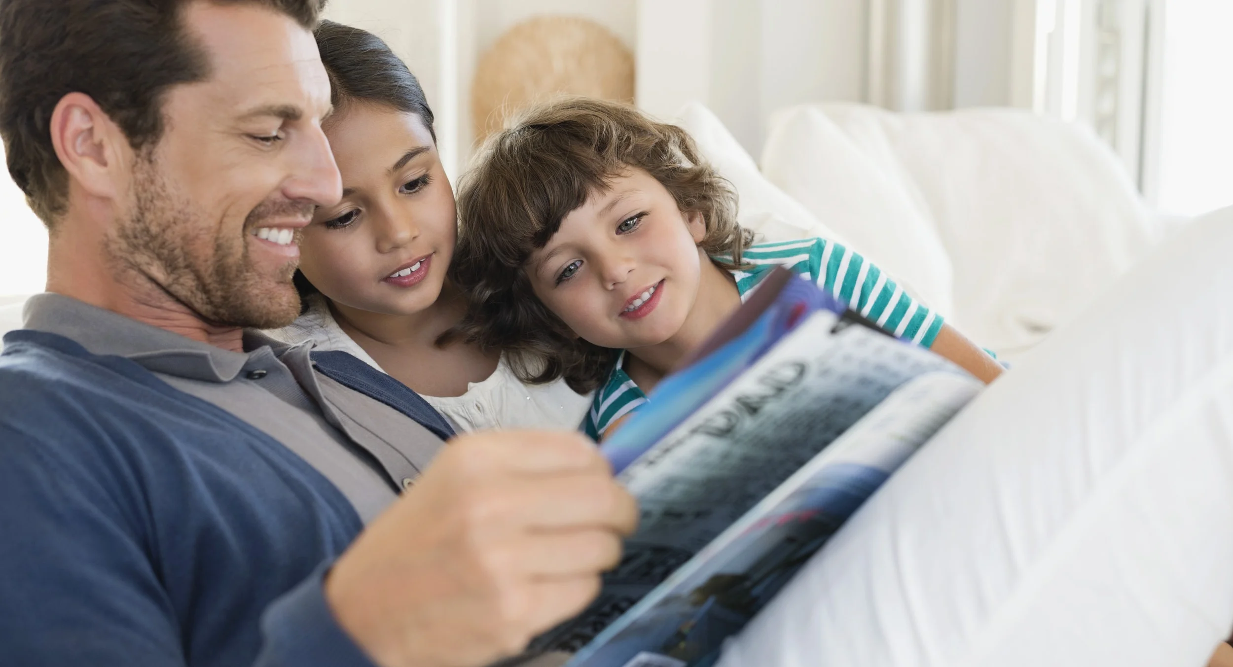 man-reading-a-magazine-with-his-children-2-min.jpg