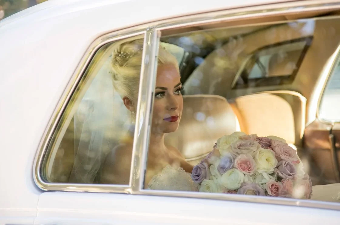 Blonde bride sitting in an old limo at Verona Park, Verona, NJ waiting to see her husband during a first look. 