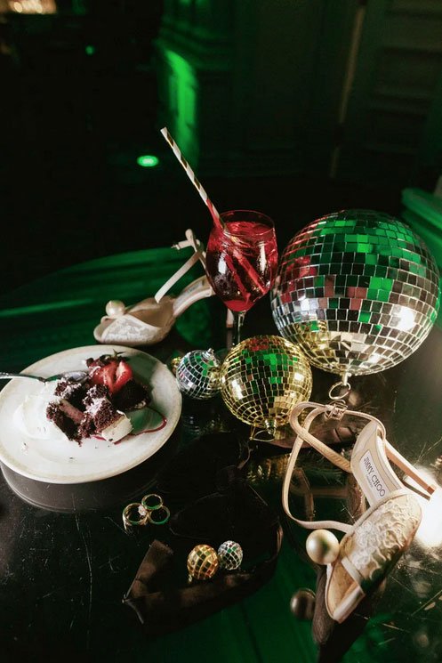 End of Wedding Reception Party Lay flat detail wedding photograph of shoes, cake, disco ball with dramatic lighting at The Park Savoy Estate. 