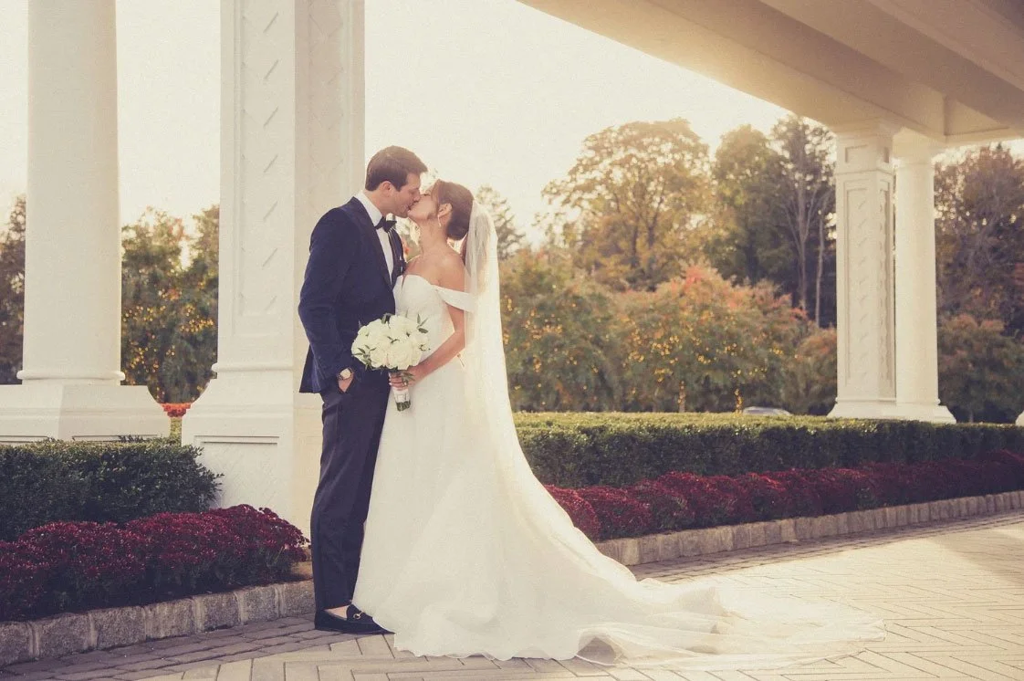Bride & Groom photographed kissing in front of the of NJ Wedding Venue, The Shadowbrook at Shrewsbury.  