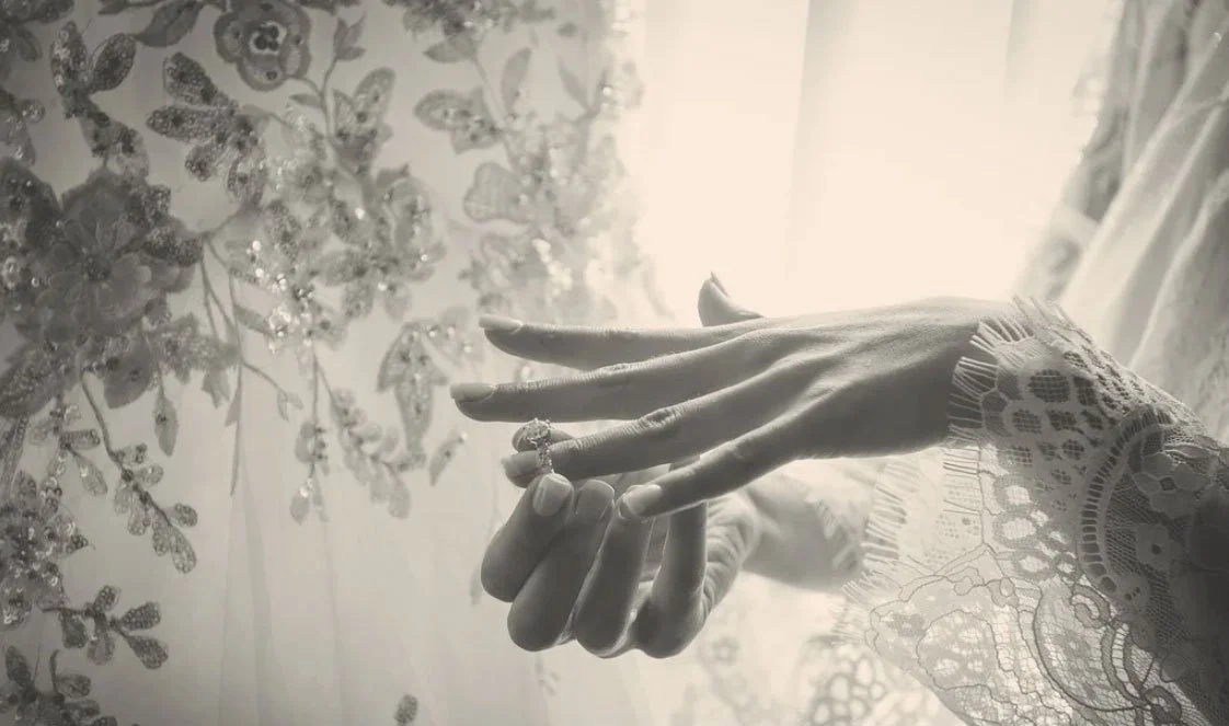 NJ Wedding Photographer Brian Delia captures a black & white light and airy style detail shot of a bride putting on her engagement ring during prep. 